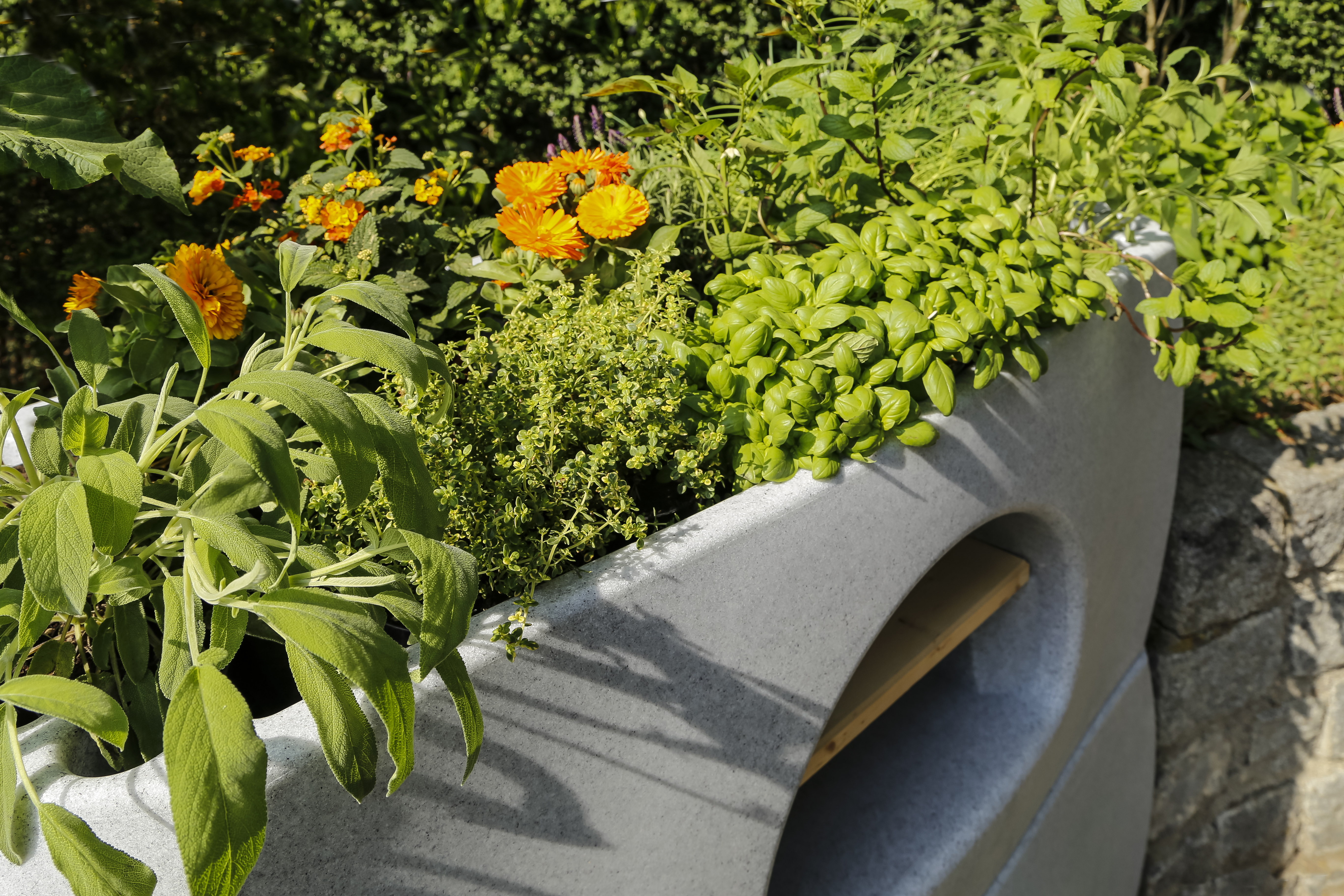 Modulares Urban Gardening Pflanzsystem in Granitfarbe mit bepflanzten Kräutern im Außenbereich